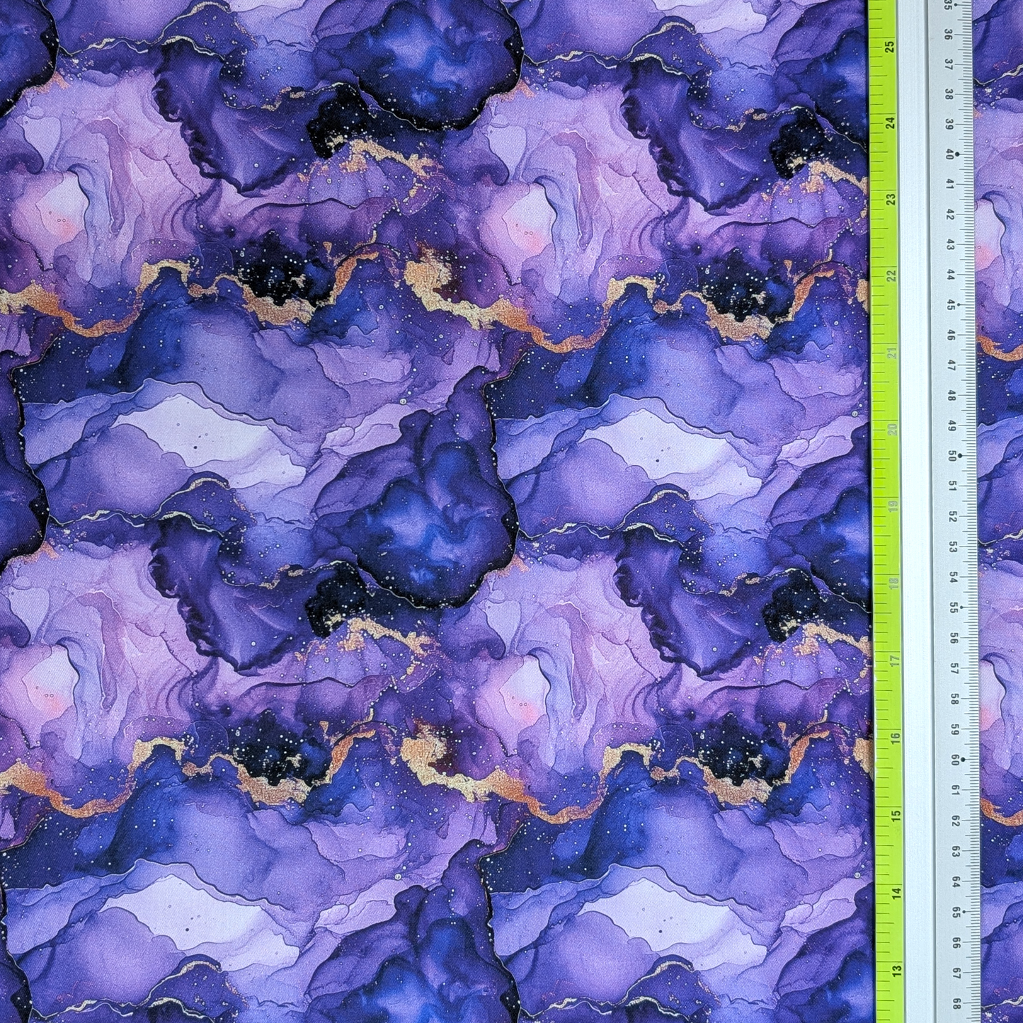 Purple and blue marbled fabric with gold accents, measured by a ruler on the right.
